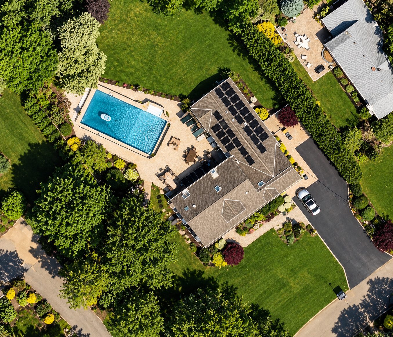 Aerial view of a Huntington home with rooftop solar and a pool