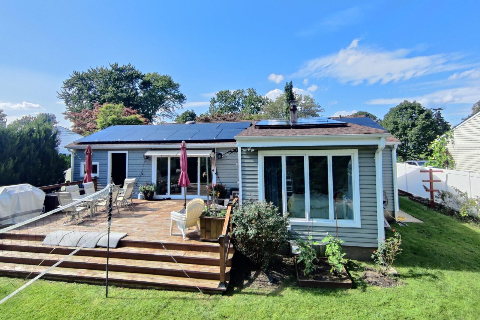 Backyard view of a Plainview ranch home with rooftop solar