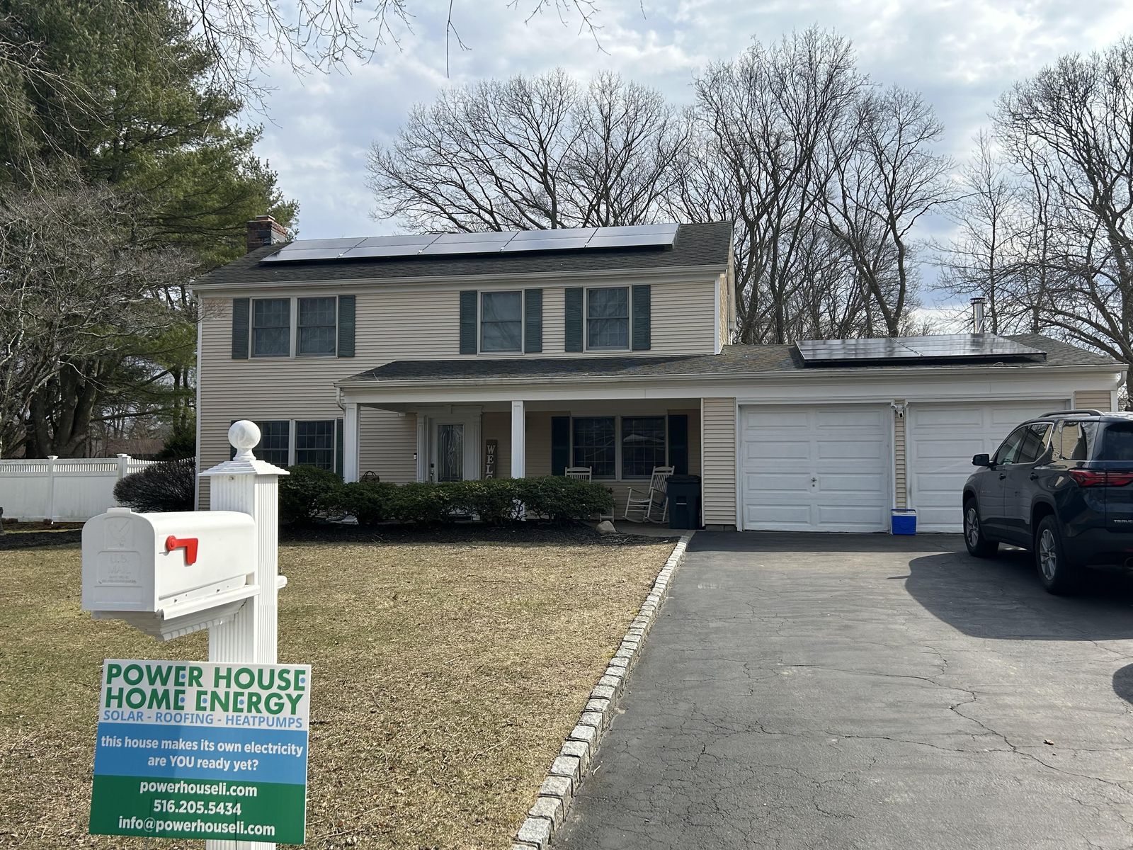 Stony Brook colonial with solar panels on the front and garage roofs