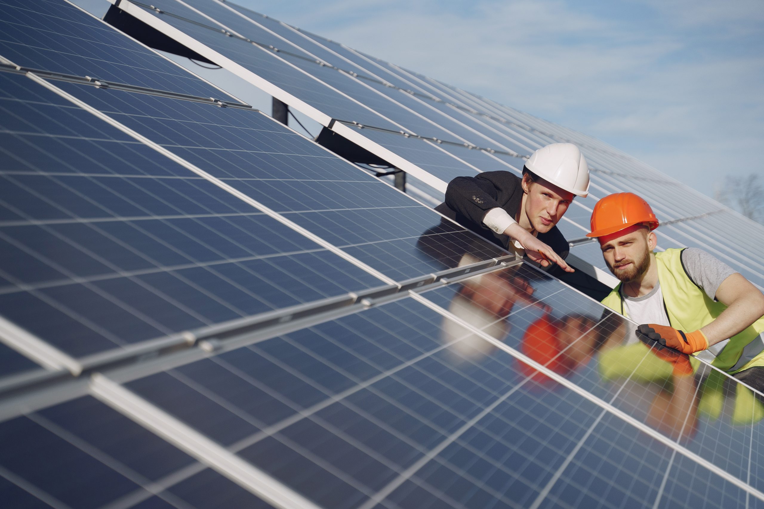 Foreman and businessman at solar energy station. Two solar professionals inspecting a solar panel that has been recently installed. Call today for a free estimate.