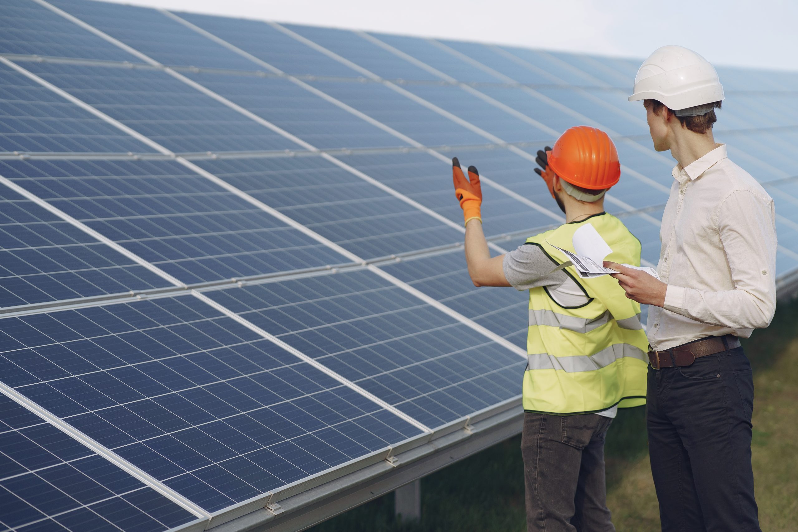 Foreman and businessman at solar energy station. Solar professionals discussing their plan after installing solar panels in a business area. To get an estimate, get in touch with us today.<br />